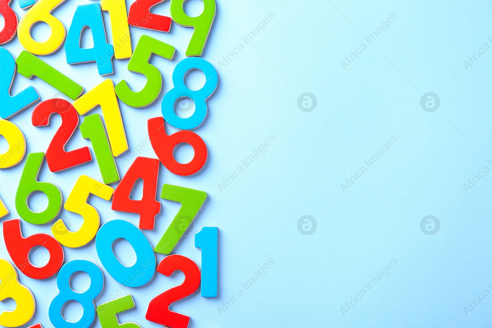 Photo of Colorful numbers on light blue background, flat lay. Space for text