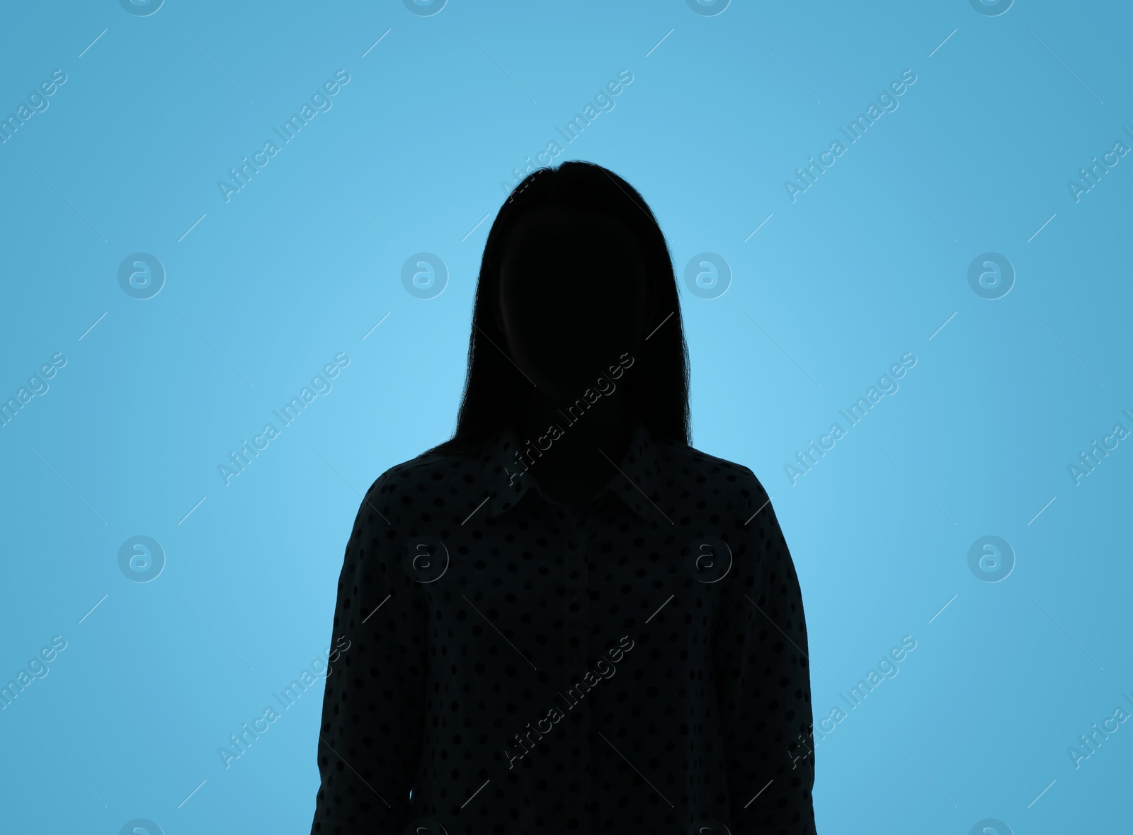 Photo of Silhouette of anonymous woman on light blue background