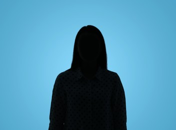 Photo of Silhouette of anonymous woman on light blue background