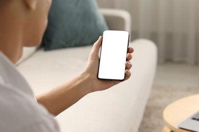 Photo of Man using smartphone with blank screen indoors, closeup. Mockup for design