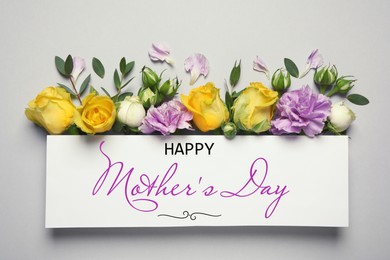 Image of Happy Mother's Day greeting card and beautiful flowers on light background, flat lay