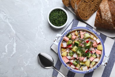 Photo of Delicious cold okroshka with kvass served on grey table, flat lay and space for text. Traditional Russian summer soup
