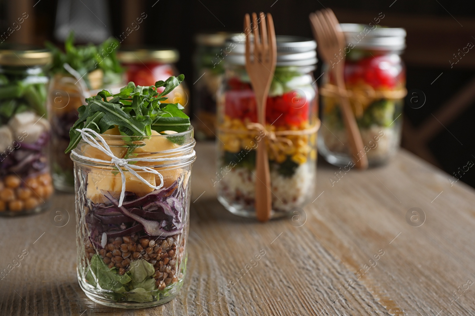 Photo of Glass jar with healthy meal on wooden table