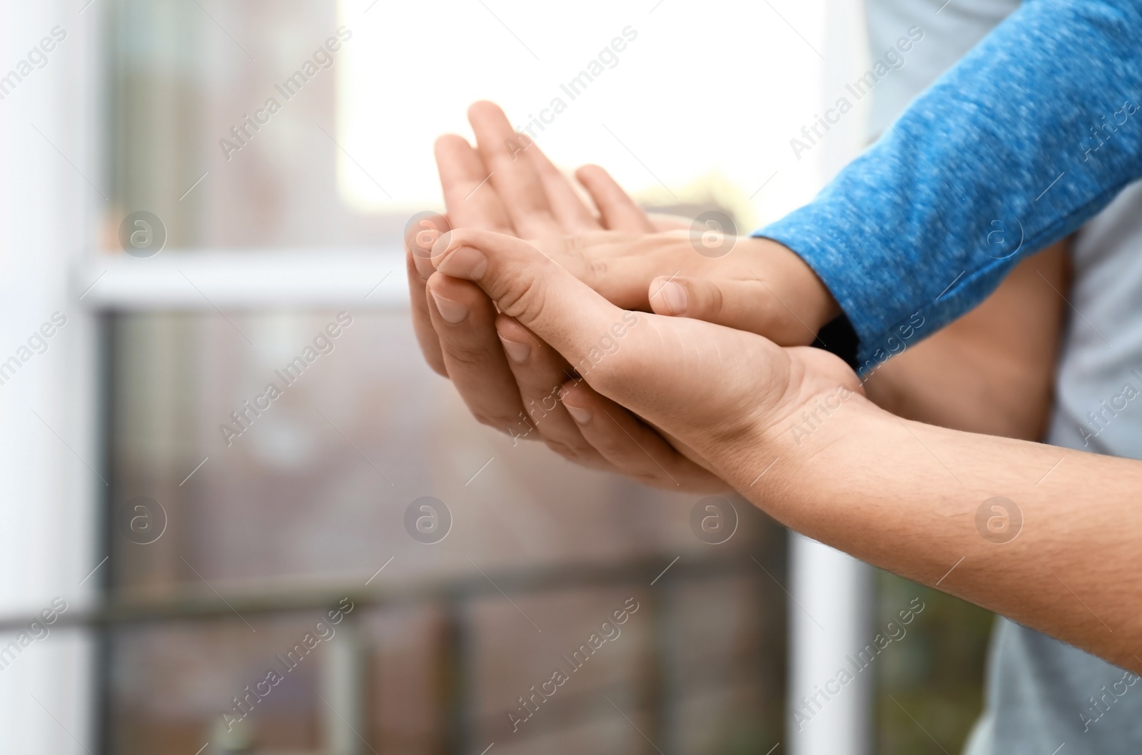 Photo of Happy family holding hands indoors, closeup view