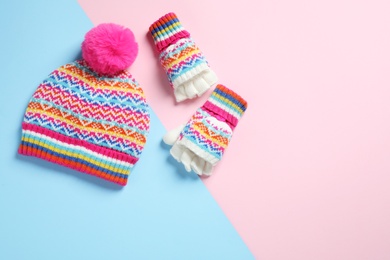Photo of Warm knitted hat and mittens on color background, flat lay. Space for text