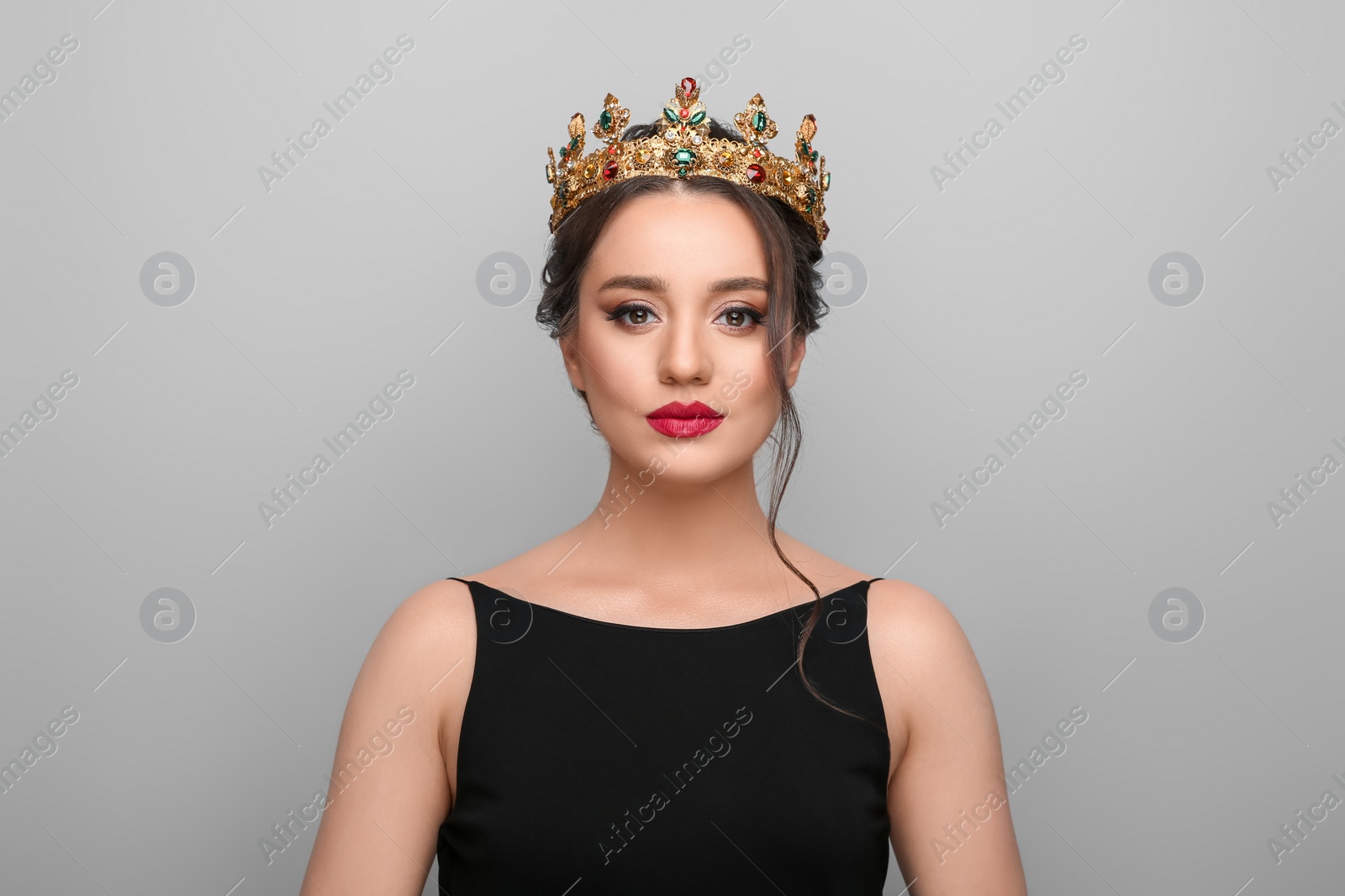 Photo of Beautiful young woman wearing luxurious crown on light grey background