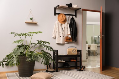 Photo of Hallway interior with stylish furniture, clothes and accessories