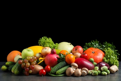 Assortment of fresh organic fruits and vegetables on grey table