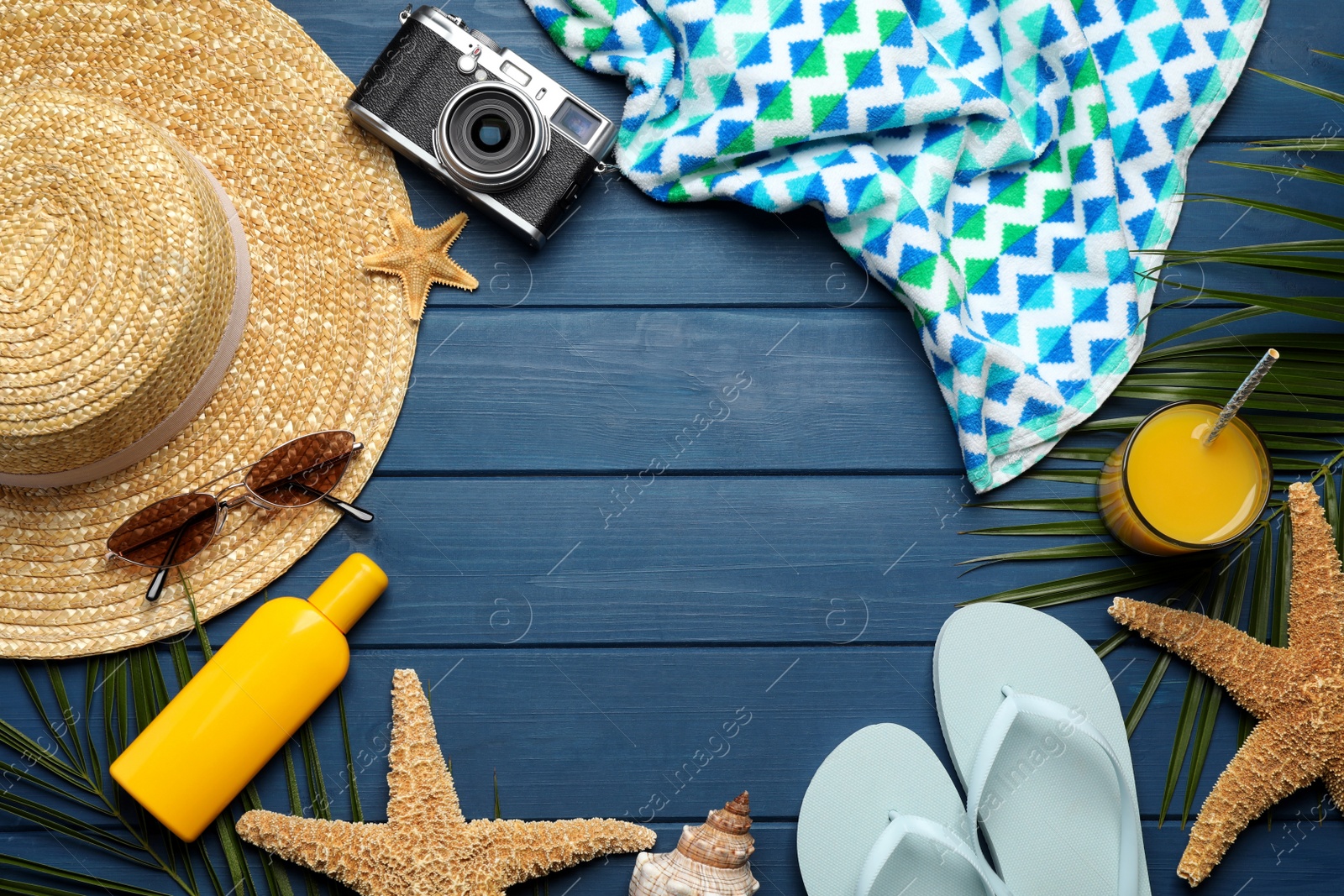 Photo of Frame of different beach objects on blue wooden background, flat lay. Space for text