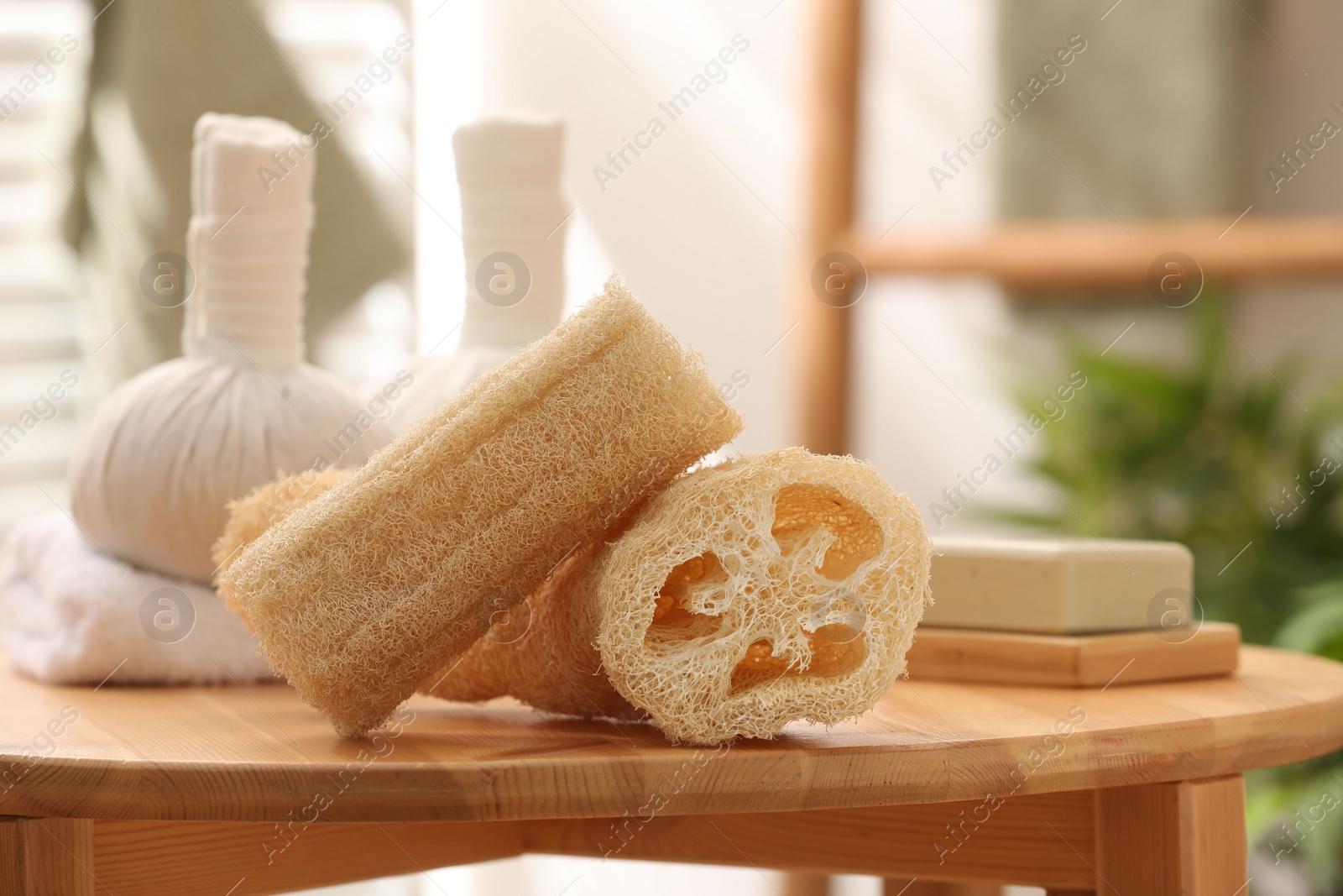 Photo of Loofah sponges on wooden table indoors, closeup. Personal hygiene products