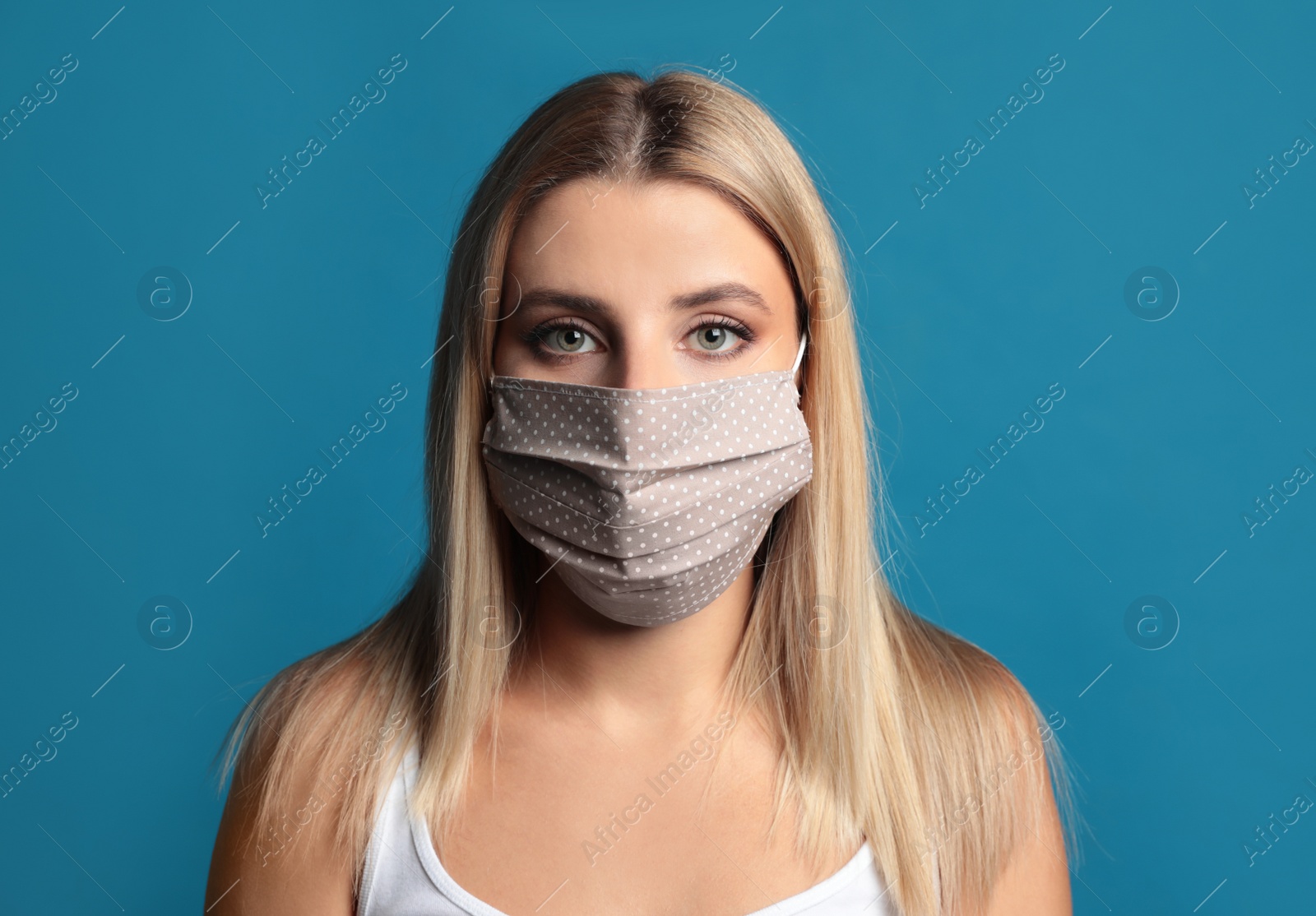 Photo of Young woman in protective face mask on blue background