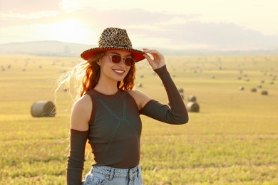 Photo of Beautiful happy hippie woman in hat in field, space for text
