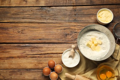 Photo of Flat lay composition with fresh butter and flour in bowl among other products on wooden table. Space for text