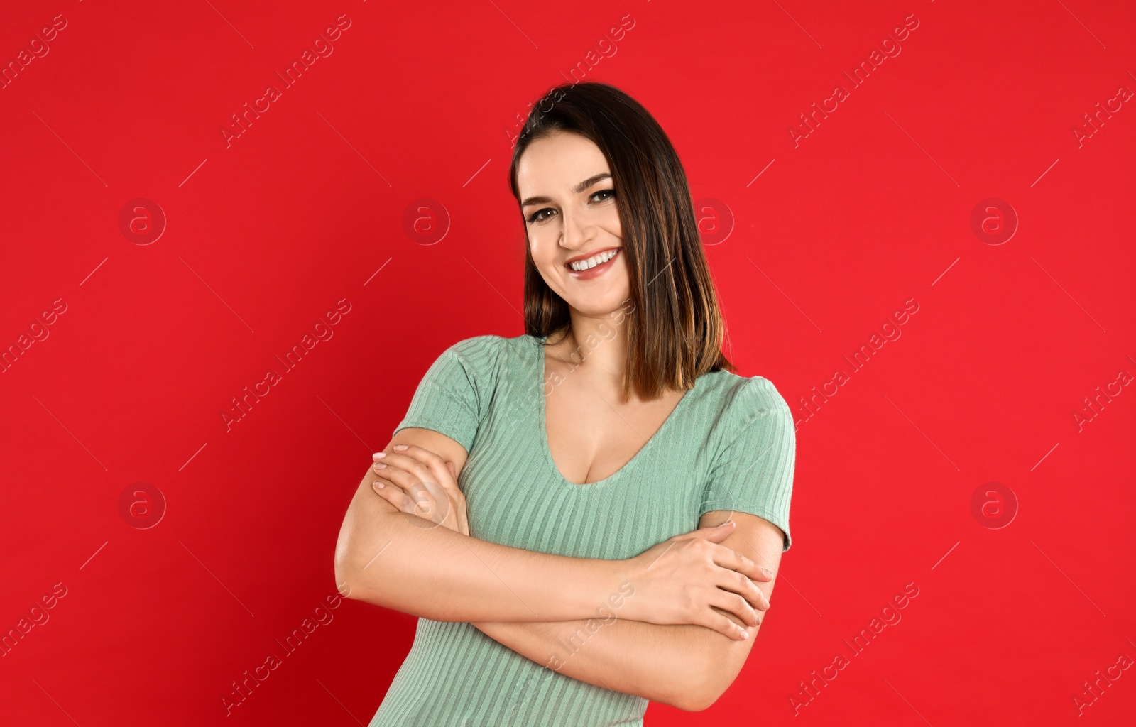 Photo of Happy beautiful young woman on red background