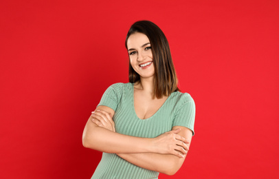 Photo of Happy beautiful young woman on red background