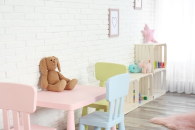 Photo of Cozy kids room interior with table, chairs and toys