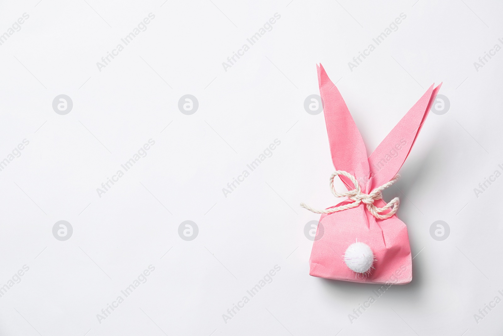 Photo of Creative Easter bunny gift bag on white background, top view