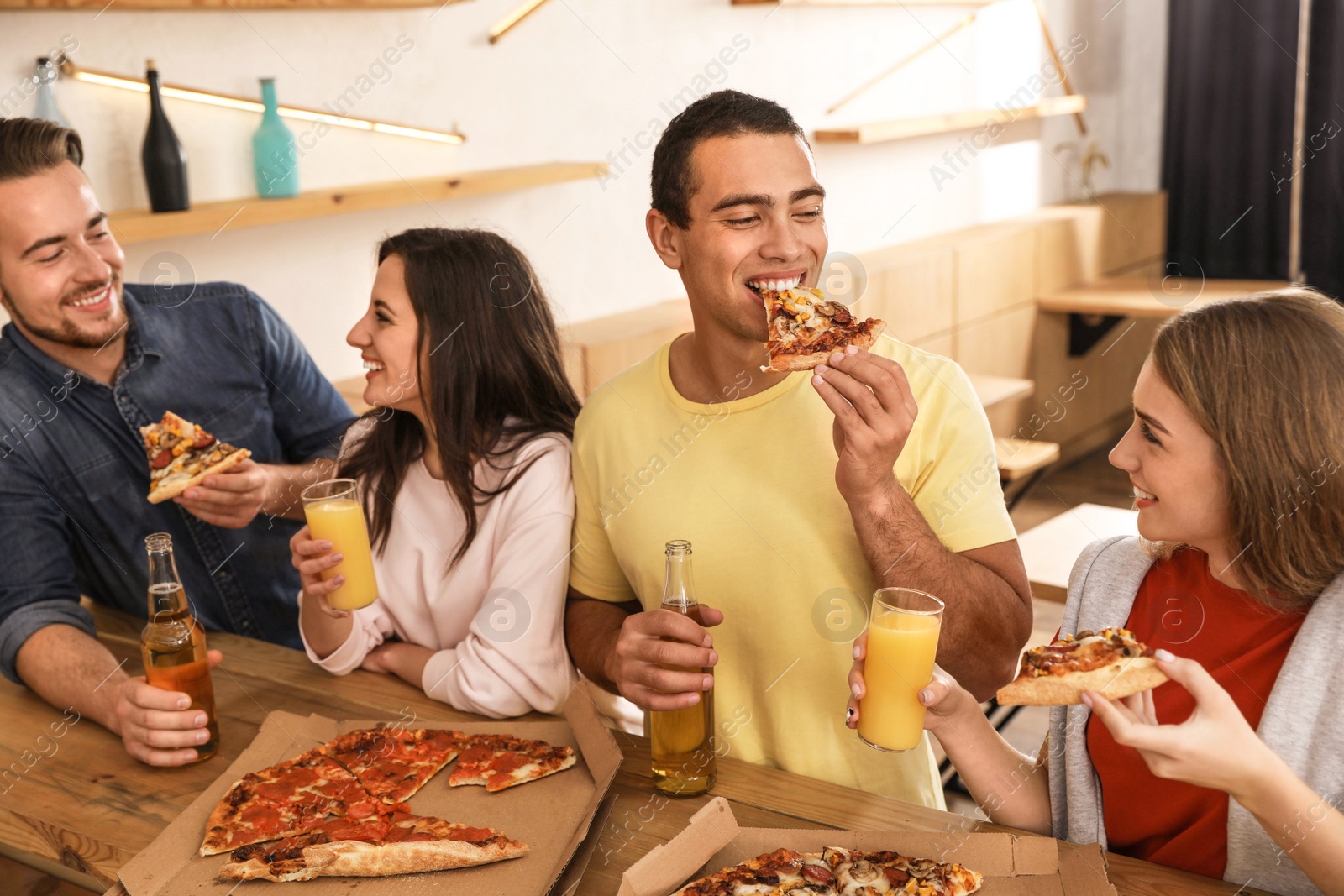 Photo of Group of friends having fun party with delicious pizza in cafe