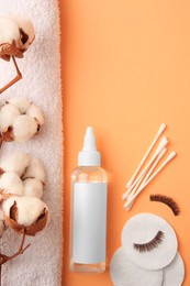 Flat lay composition with makeup remover and cotton flowers on pale orange background, space for text