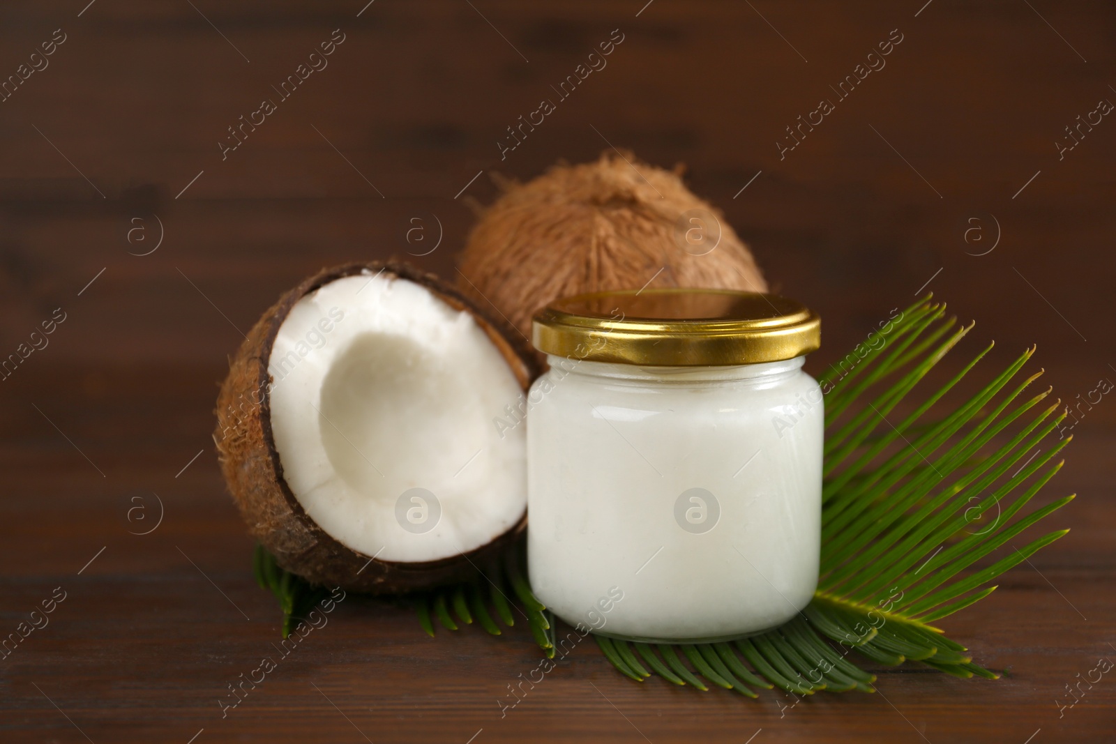 Photo of Composition with organic coconut oil on wooden table. Healthy cooking