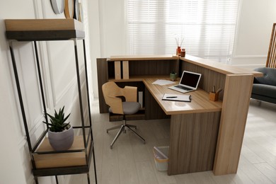 Photo of Receptionist's workplace with laptop in hotel. Interior design