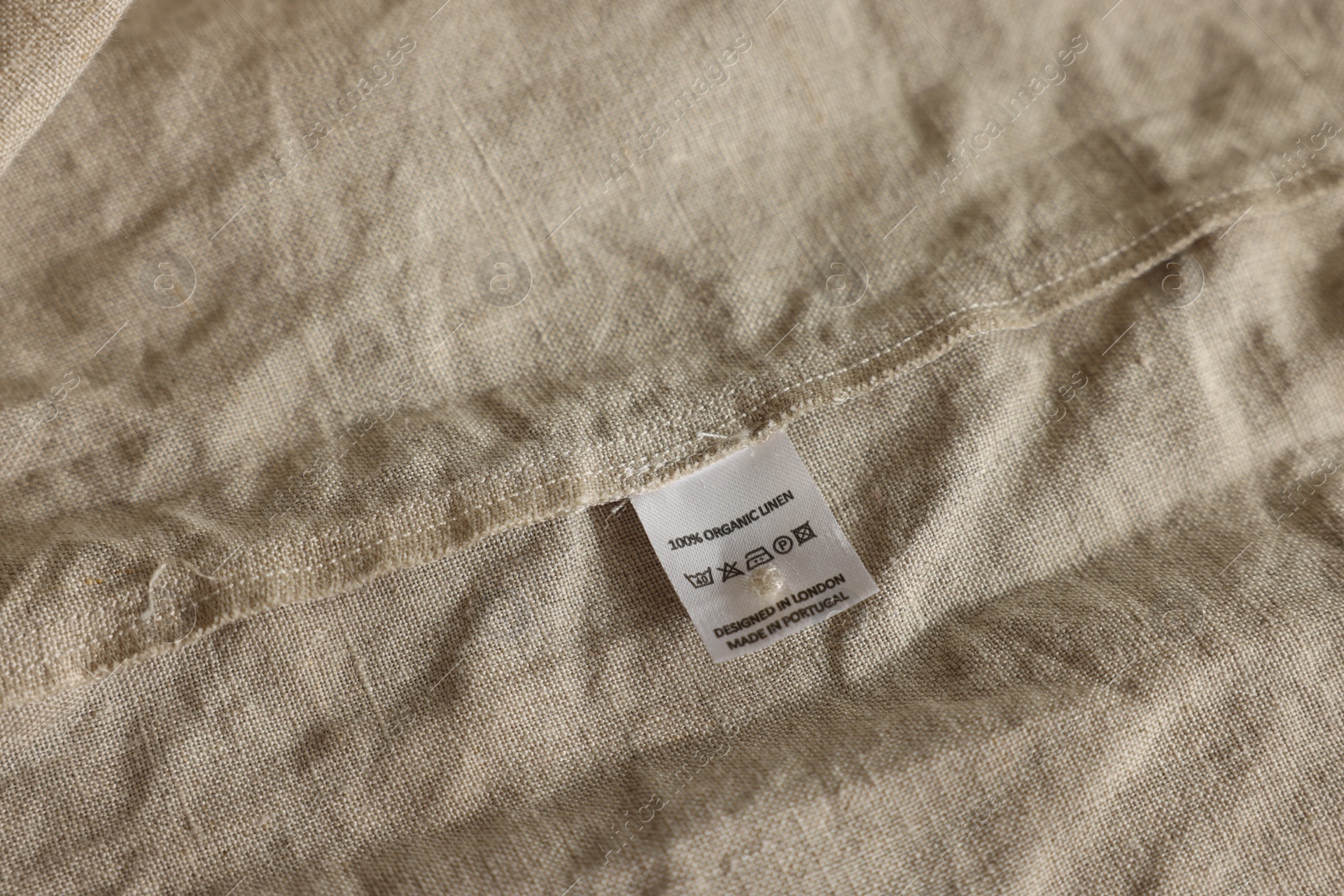 Photo of Clothing label on beige garment, closeup view