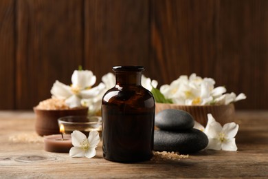 Photo of Beautiful composition with jasmine essential oil and fresh flowers on wooden table