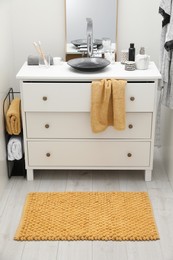 Photo of Mat near base cabinet with sink in bathroom