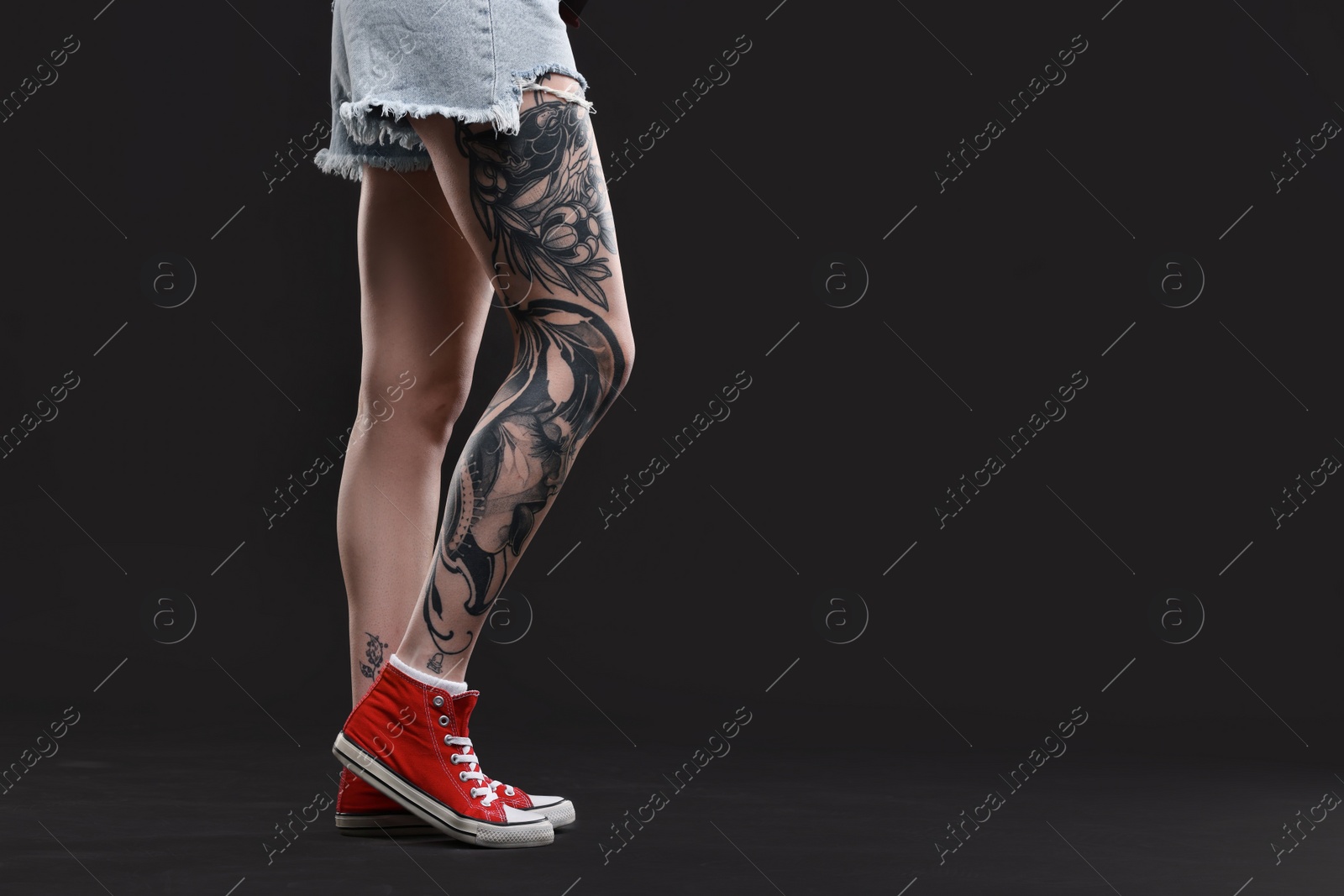 Photo of Woman with cool tattoos on black background, closeup. Space for text