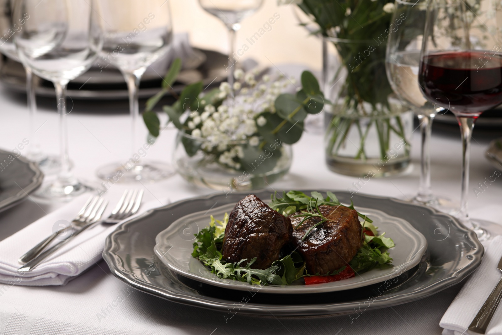 Photo of Delicious grilled meat with vegetables and wine served on table in restaurant