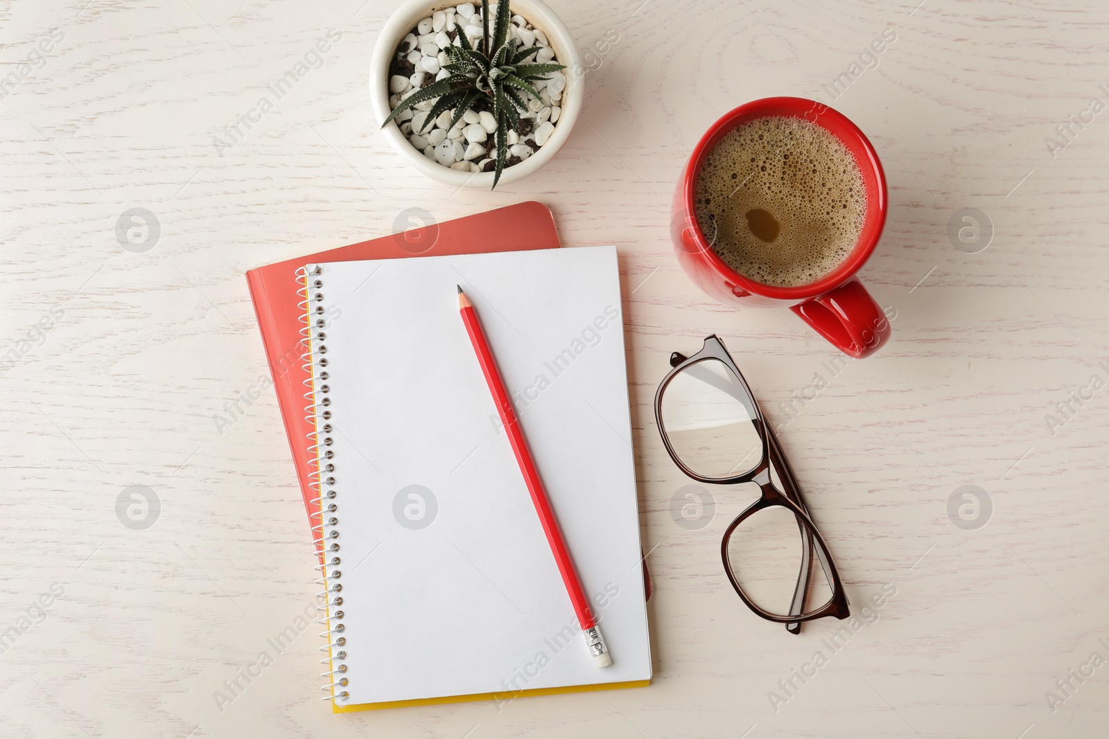 Photo of Flat lay composition with office stationery and cup of coffee on white wooden table