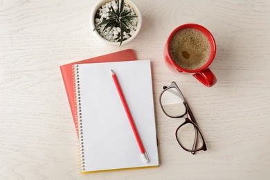 Photo of Flat lay composition with office stationery and cup of coffee on white wooden table