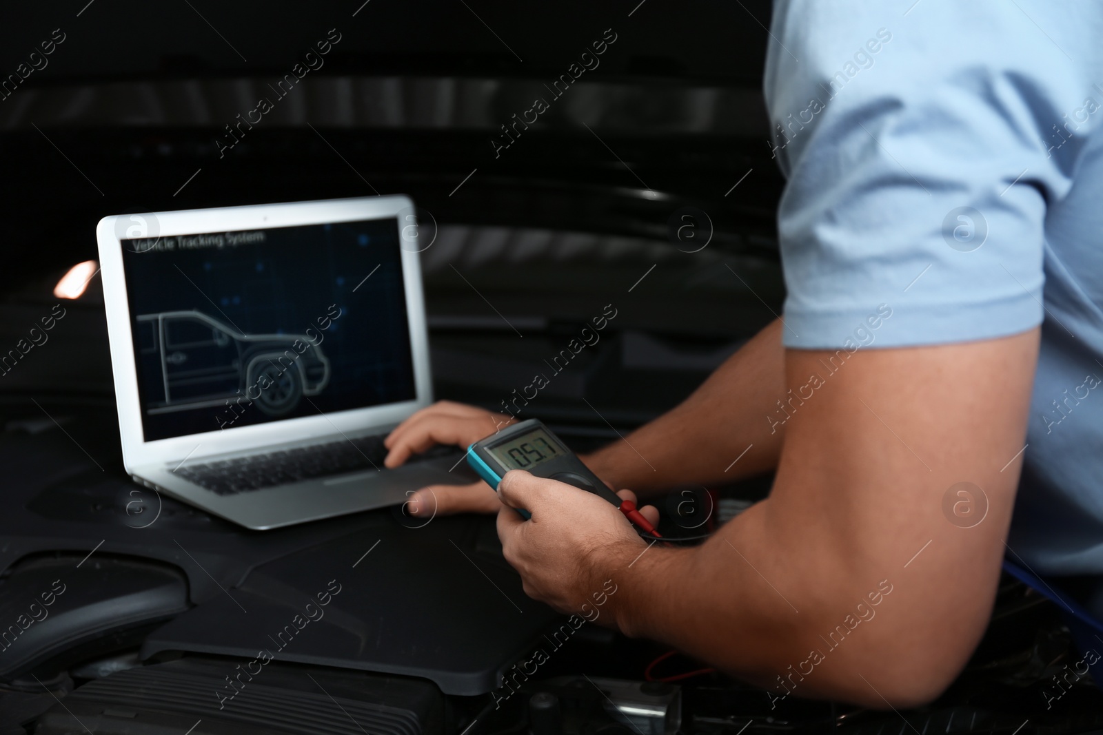 Photo of Mechanic with laptop doing car diagnostic at automobile repair shop, closeup