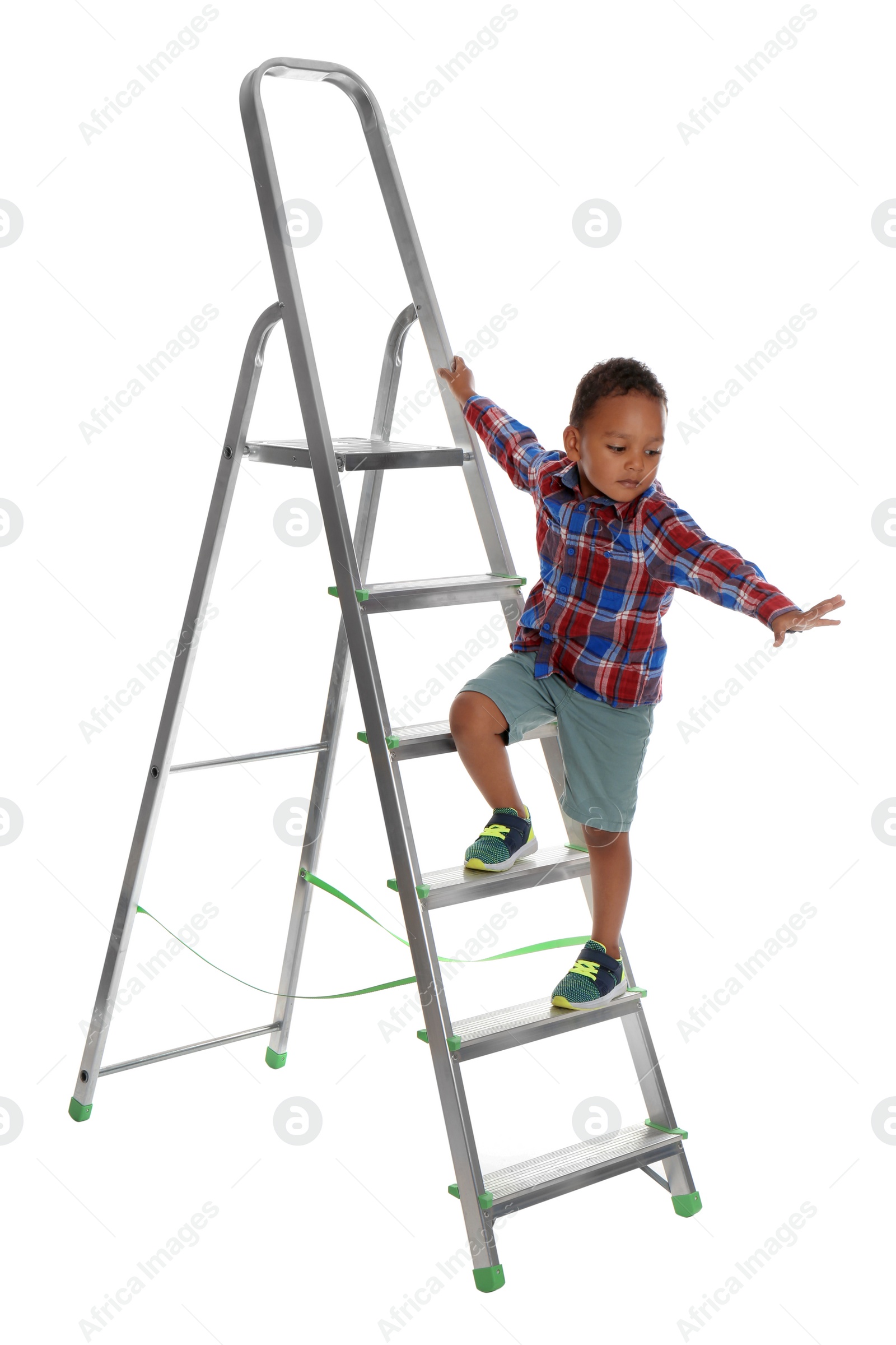 Photo of Little African-American boy climbing up ladder on white background. Danger at home