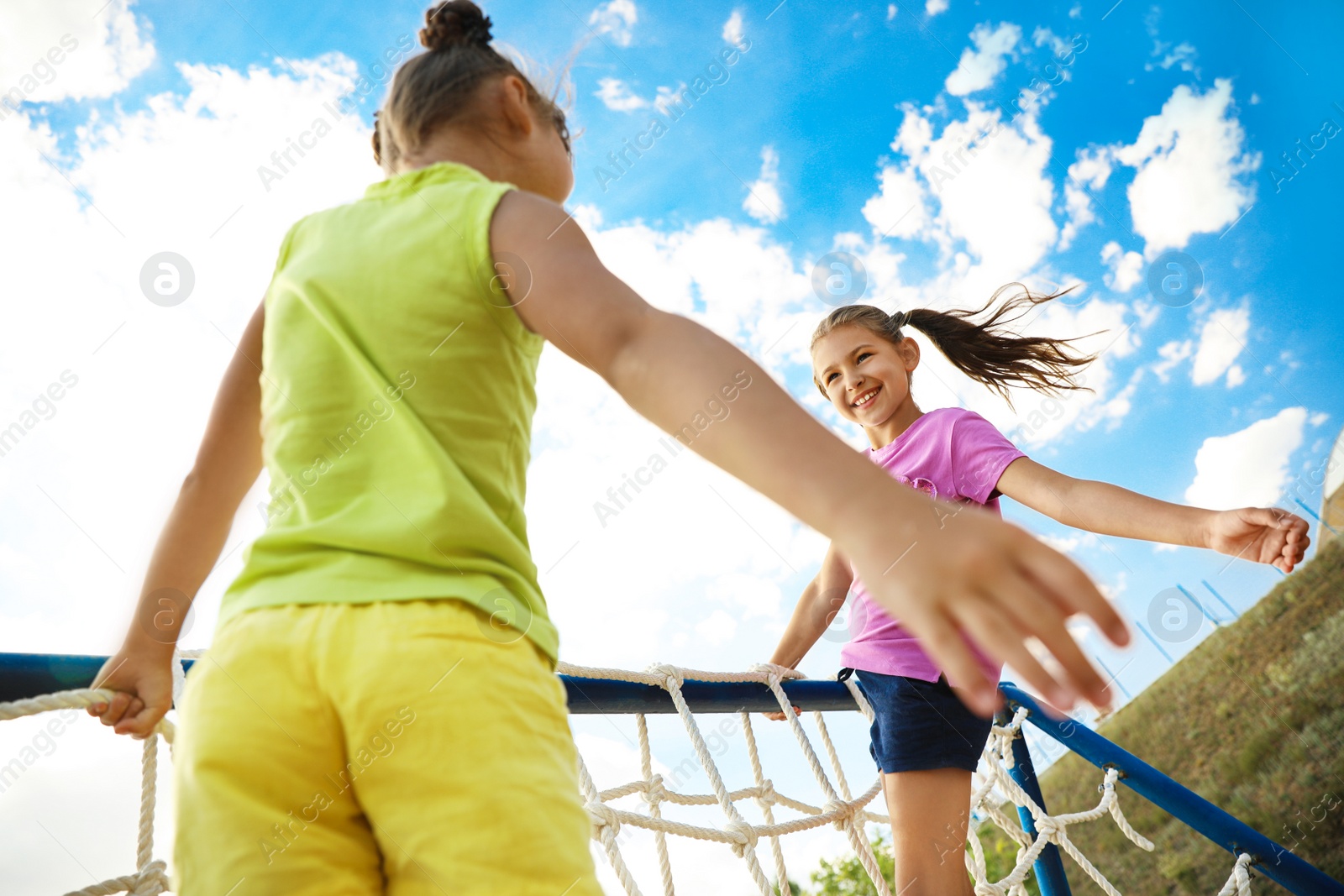 Photo of Cute children on playground rope climber outdoors. Summer camp