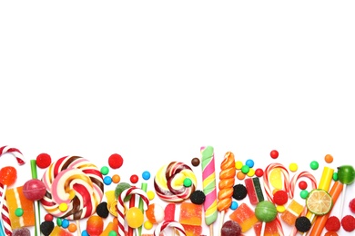 Many different yummy candies on white background, top view. Space for text