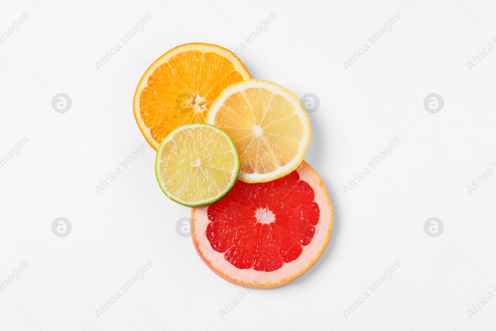 Photo of Slices of fresh ripe citrus fruits on white background, flat lay