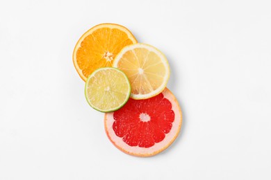 Photo of Slices of fresh ripe citrus fruits on white background, flat lay