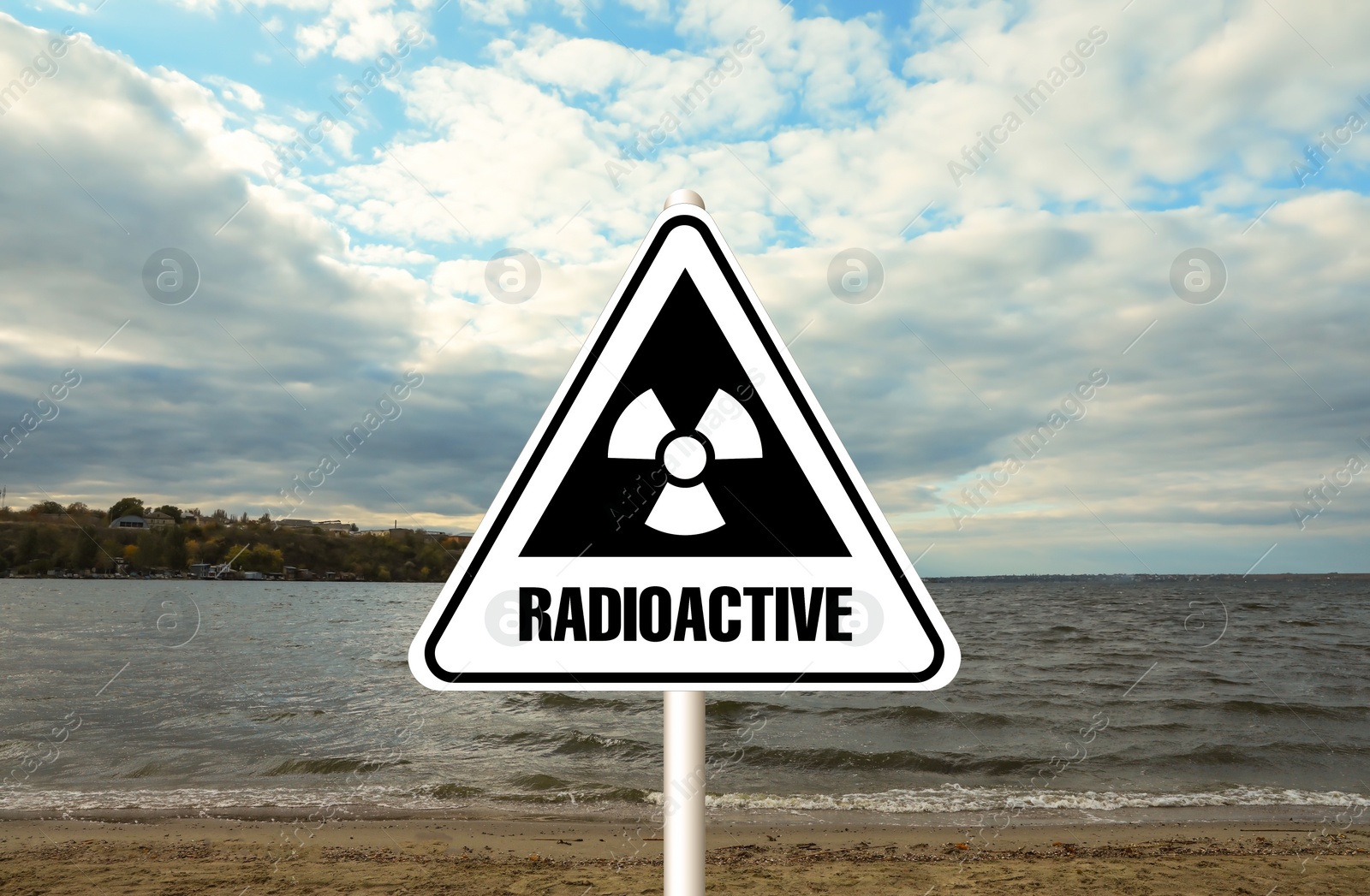 Image of Radioactive pollution. Warning sign with hazard symbol near sea side