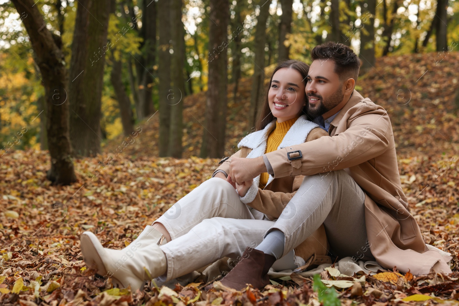 Photo of Romantic young couple spending time together in autumn park, space for text