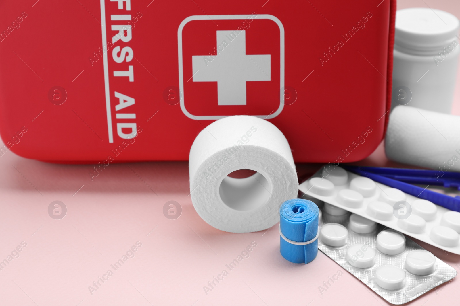 Photo of First aid kit on pink background, closeup