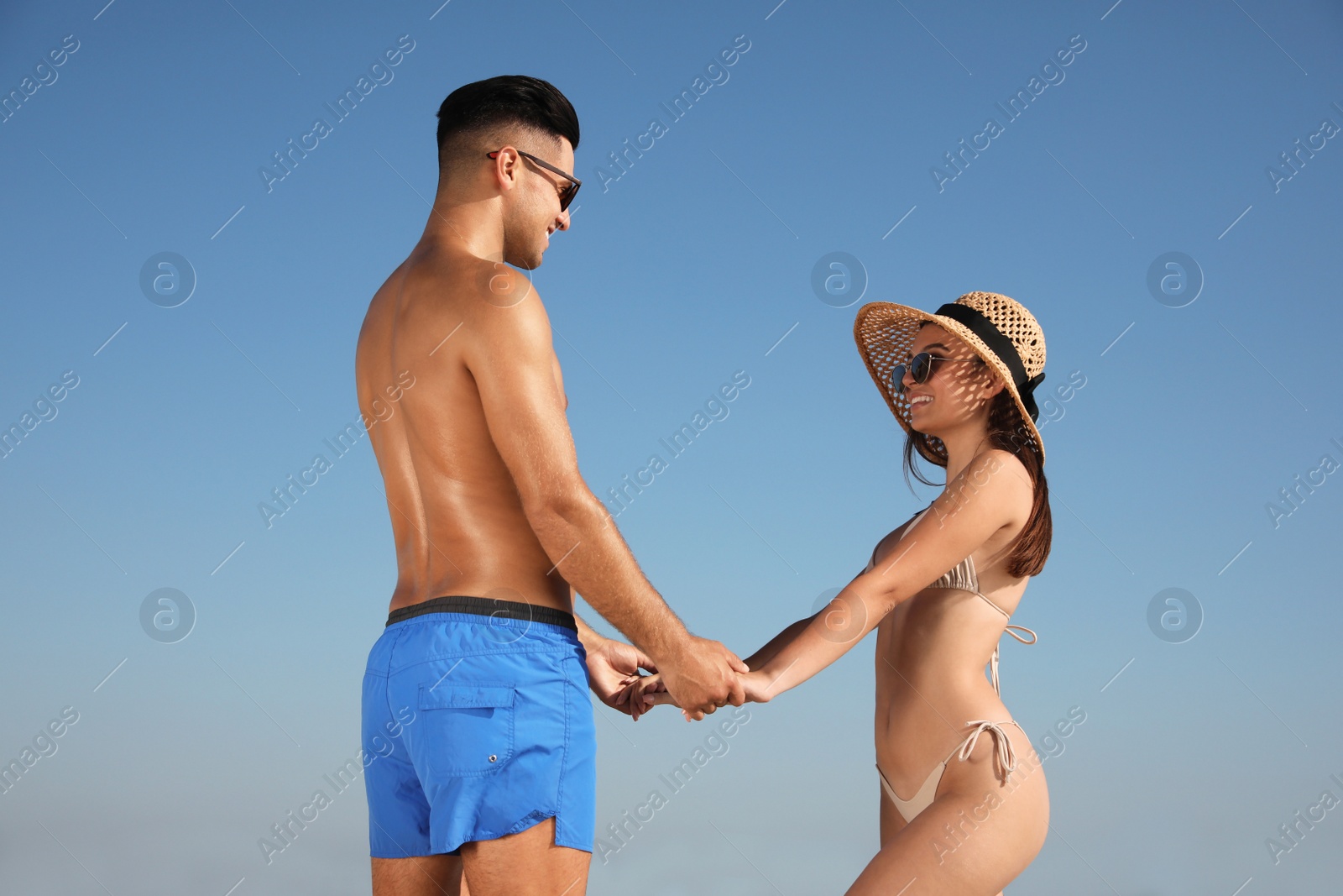 Photo of Lovely couple holding hands against blue sky