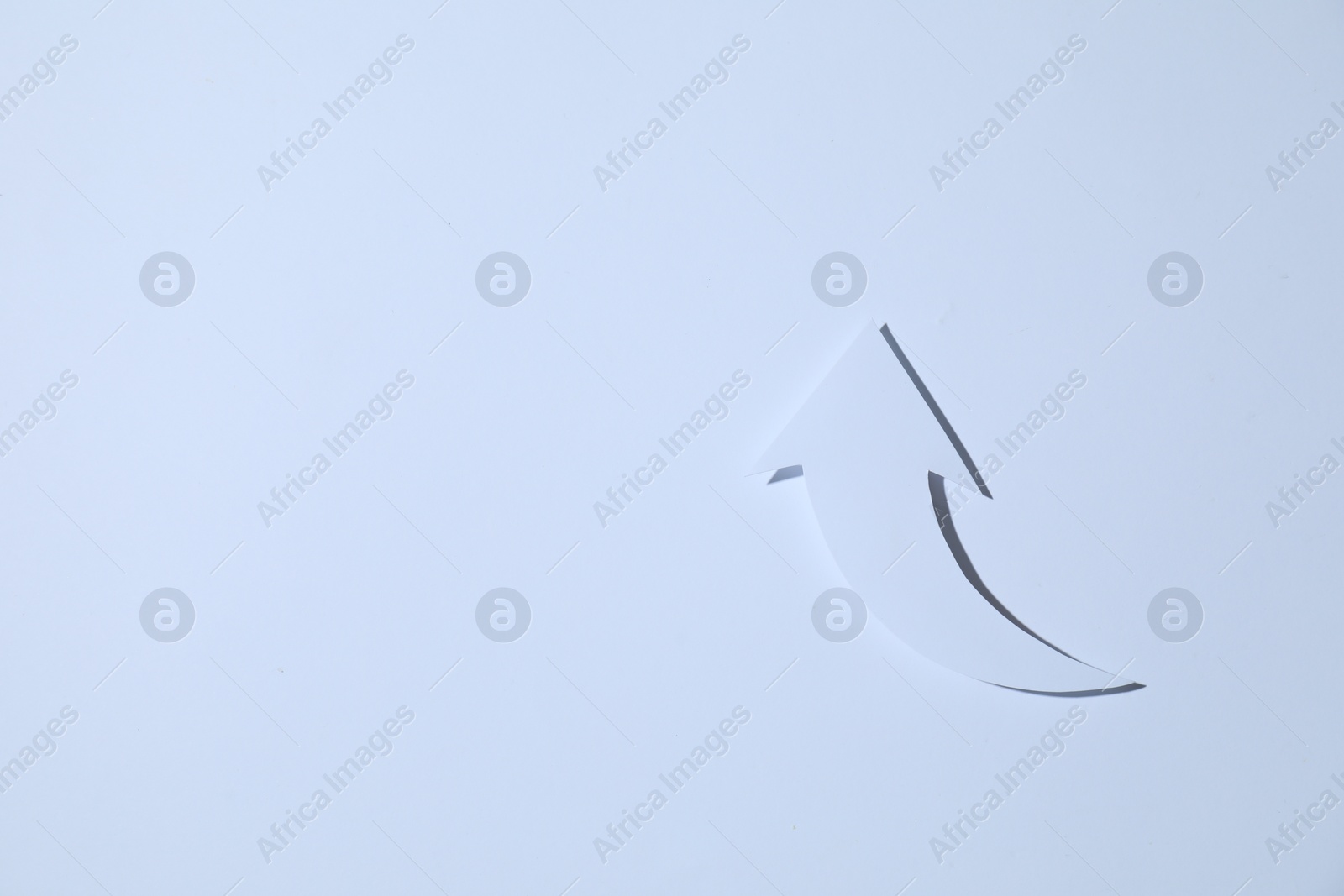 Photo of Curved paper arrow on white background, top view. Space for text