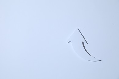 Photo of Curved paper arrow on white background, top view. Space for text