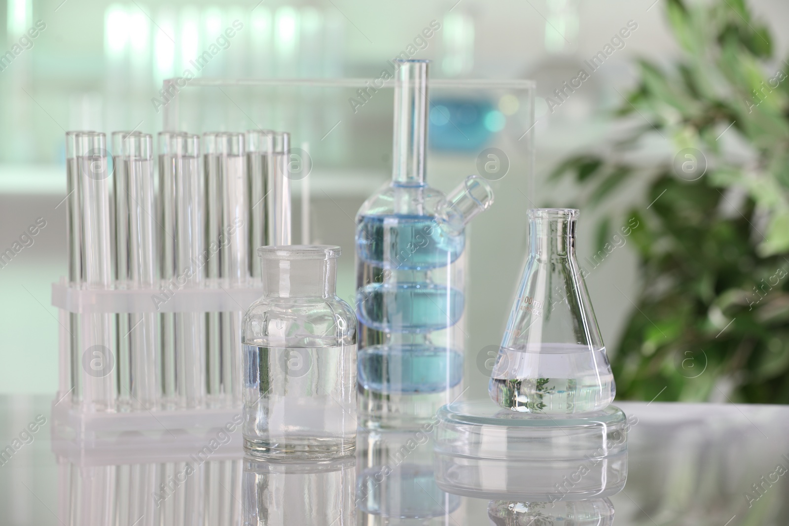 Photo of Laboratory analysis. Different glassware with liquid on white table indoors