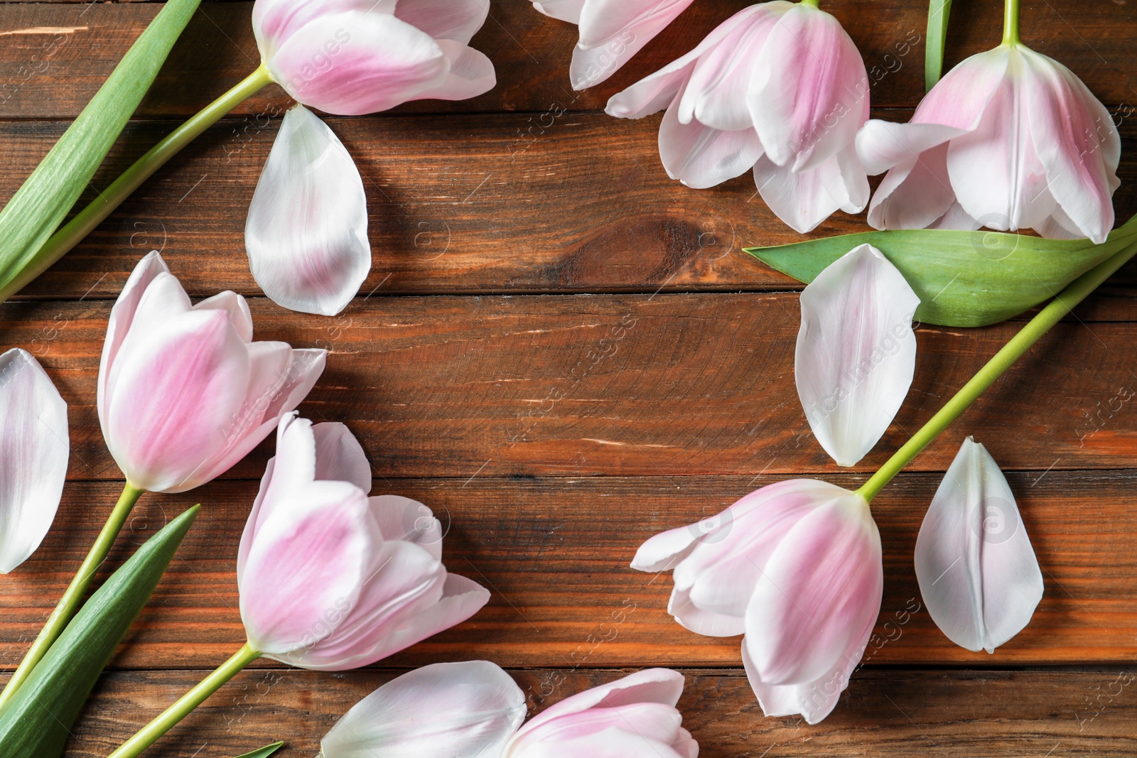 Photo of Beautiful frame made of tulips for Mother's Day on wooden background