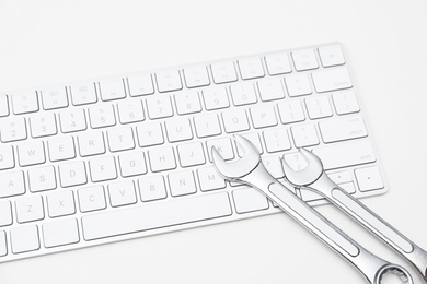 Photo of Wrenches and computer keyboard on light background. Concept of technical support