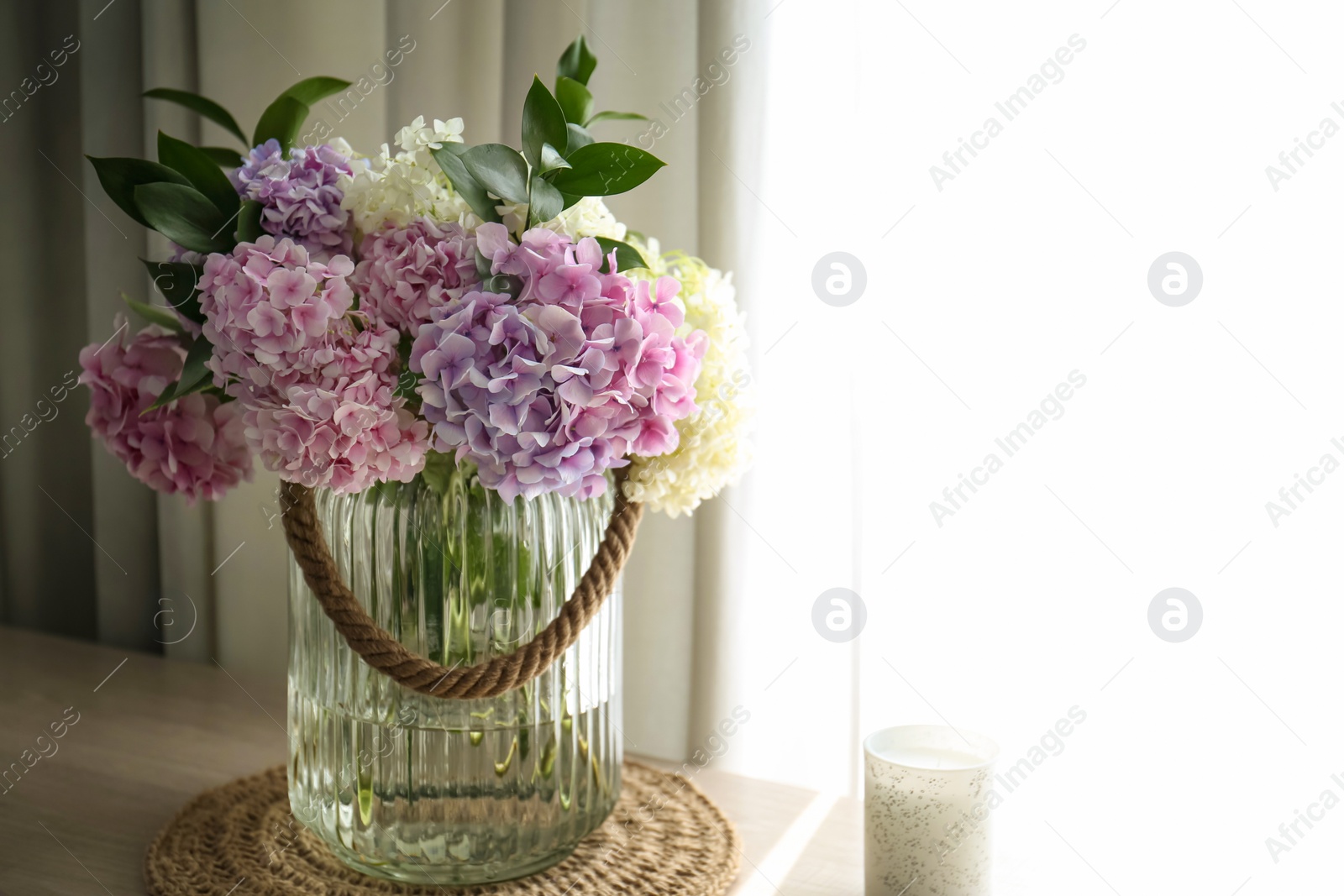 Photo of Bouquet of beautiful hydrangea flowers on table near window, space for text. Interior design