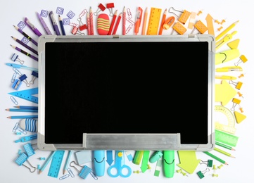 Photo of Composition with different school stationery and small chalkboard on white background, top view