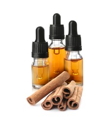 Image of Bottles of natural essential oil and dry cinnamon sticks on white background